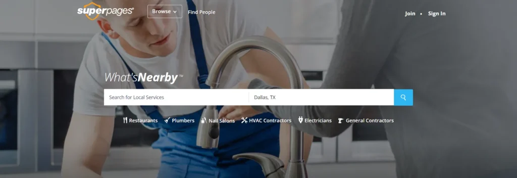 Superpages homepage showing a plumber fixing a sink, with a search bar for local services like restaurants, electricians, and contractors.