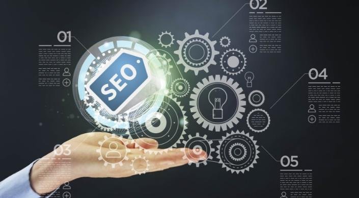 Hand holding SEO icon with interconnected gears symbolizing technical SEO components and optimization processes.